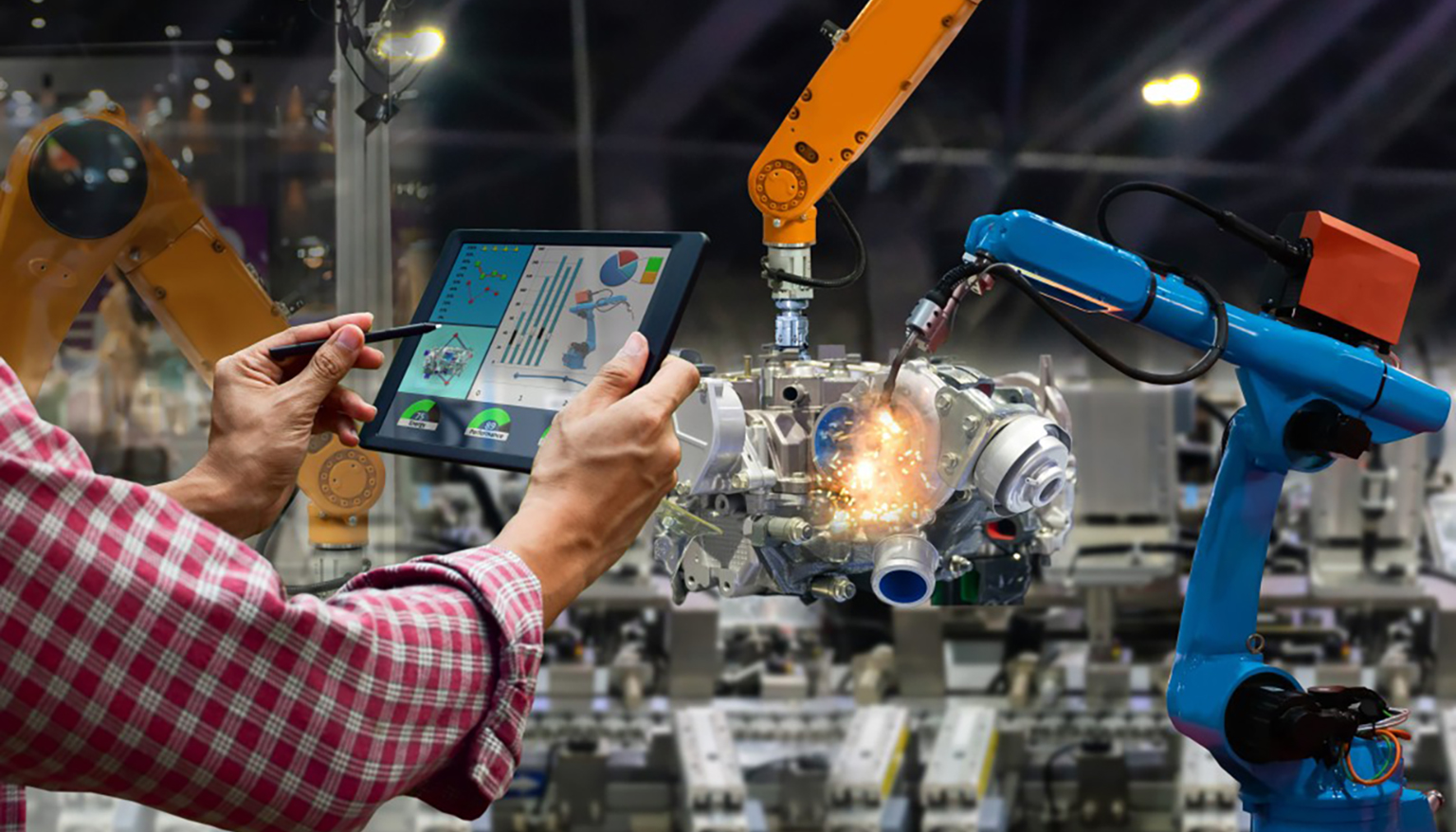 Uomo utilizza un tablet per monitorare in tempo reale un sistema cyberfisico con robot collaborativi e macchinari automatizzati, migliorando l'efficienza della produzione industriale nell'ambito dell'Industria 4.0.