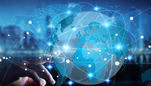Globo digitale con connessioni globali e una mano che interagisce con i punti di connessione. L’immagine rappresenta strategie di marketing in lingua straniera per espandersi nei mercati esteri.
